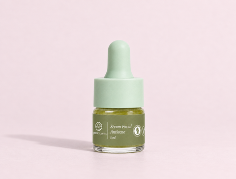 Mini Sérum Facial Antiacne de 5 ml para gestantes, frasco de vidro com conta-gotas verde-menta sobre fundo rosa claro