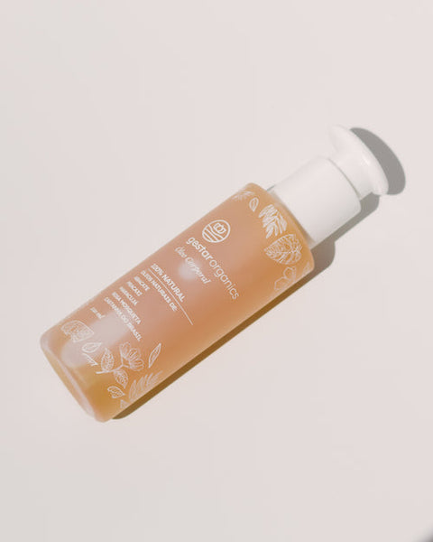 Frasco âmbar com tampa pump branca do Óleo Corporal Anti-Estrias, skincare para gestantes, sobre fundo claro